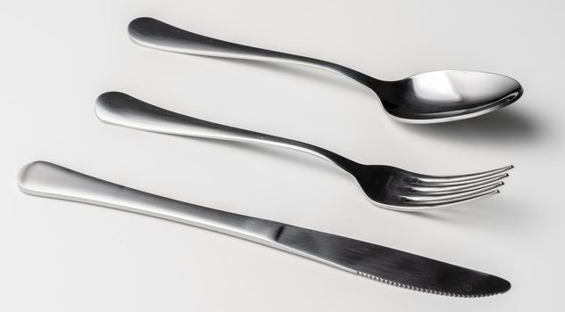 Spoon, fork and knife on a white background. Close up.