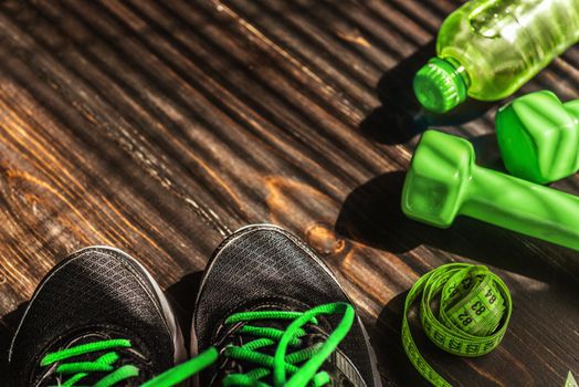 Sneakers dumbbells and a bottle of water. Flat view. All in one color.