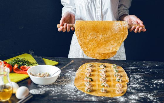 Woman chef cooks step by step the traditional ravioli