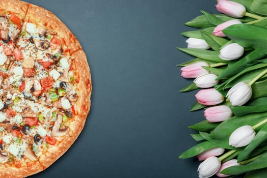 fresh pizza and spring flowers tulips. with space for text