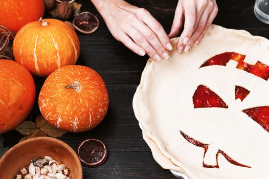 Chef cooks a pie for Halloween with a filling of pumpkin-strawberry jam and peaches