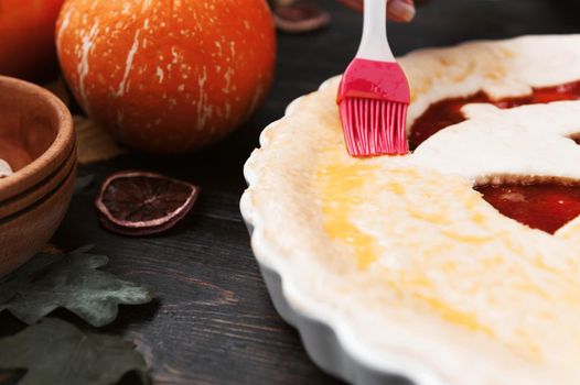 Chef cooks a pie for Halloween with a filling of pumpkin-strawberry jam and peaches