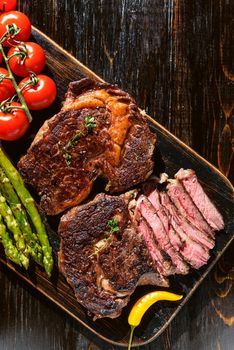 Dinner for two juicy delicious steaks, asparagus with parmesan and vegetables.