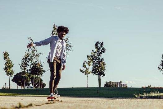 Young african american man skateboarding in modern park