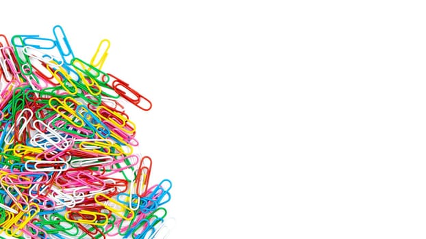 Many color stationery paper clips on a white background. Top view and copy space.