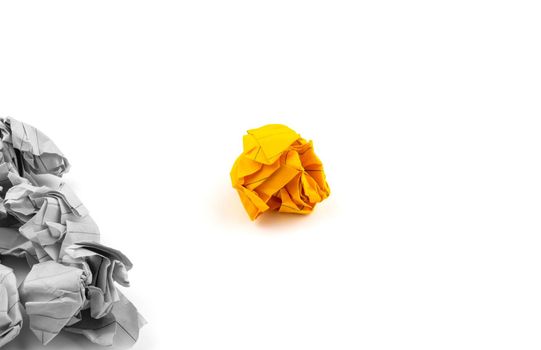 Concept or illustration of leadership, management or loneliness and uniqueness with the help of crumpled pieces of paper of orange and gray color on a white background