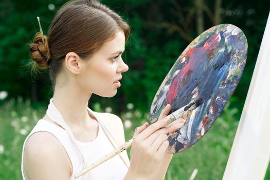 woman artist nature paints palette easel creative landscape. High quality photo