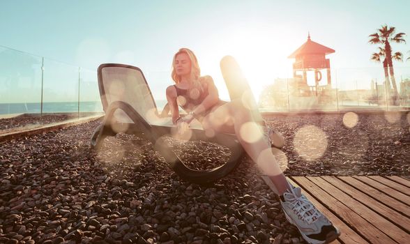 girl in a bathing suit and sneakers on a lounger