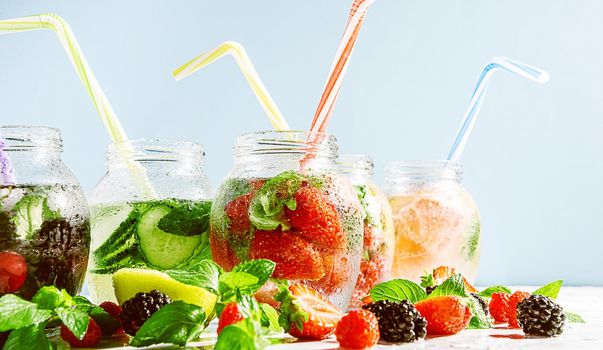 detox smoothies of fresh fruits and vegetables in glass jars with tubes. studio light, light background, space for text