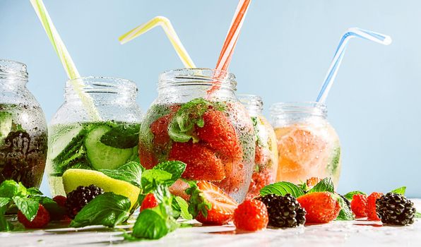 detox smoothies of fresh fruits and vegetables in glass jars with tubes. studio light, light background, space for text