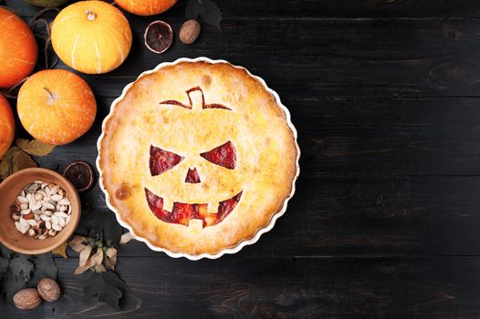 Delicious homemade pie for halloween with a filling of pumpkin-strawberry jam and peaches