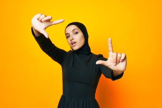 Muslim happiness fashion clothing hand gesture yellow background. High quality photo