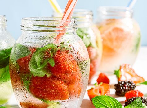 detox smoothies of fresh fruits and vegetables in glass jars with tubes. studio light, light background, space for text