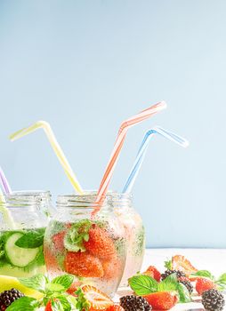 detox smoothies of fresh fruits and vegetables in glass jars with tubes. studio light, light background, space for text