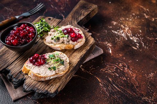 Duck rillettes pate toasts with sprouts on a wooden board. Dark background. Top View. Copy space.