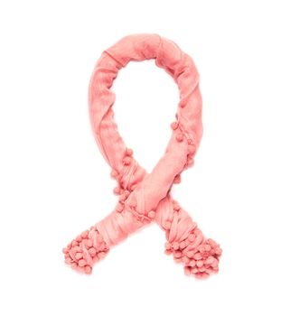 Pink aids ribbon of twisted delicate fabric isolated on white background.