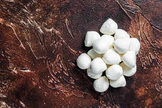 Buffalo mozzarella cheese mini balls on kitchen table. Dark background. Top view. Copy space.