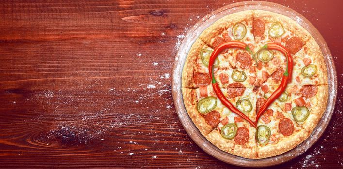 Valentine's Day pizza with peppers laid on top of a pizza