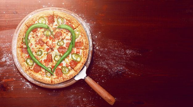 Valentine's Day pizza with peppers laid on top of a pizza