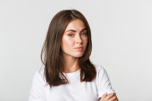 Close-up of attractive brunette girl looking skeptical and unamused.