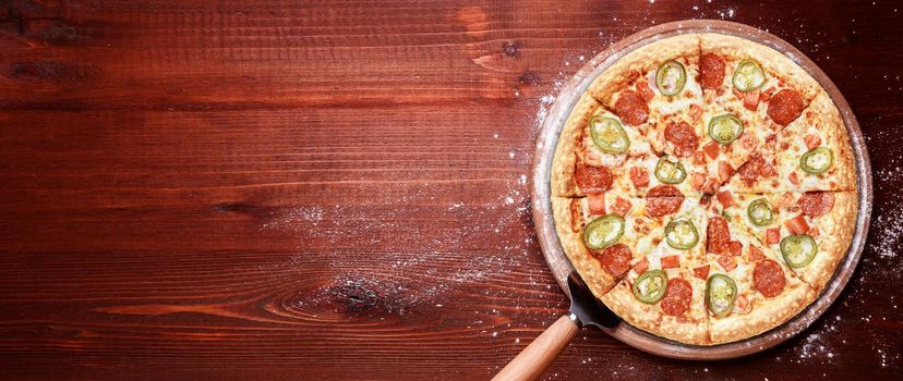 fresh american pizza on wooden table with space for text