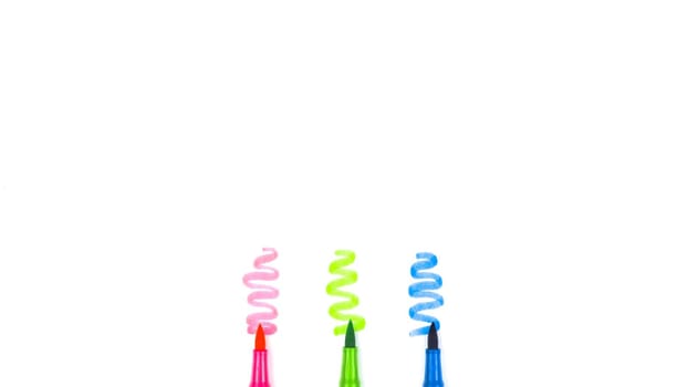 Three multicolored markers on a white background with copy space.
