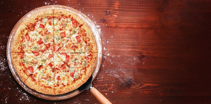 fresh american pizza on wooden table with space for text