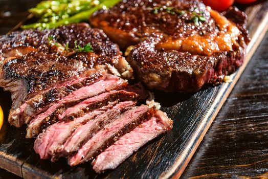 Dinner for two juicy delicious steaks, asparagus with parmesan and vegetables.