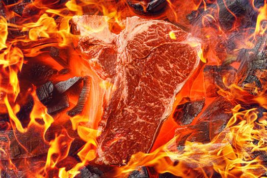 raw marbled beef steak with coals and smoke