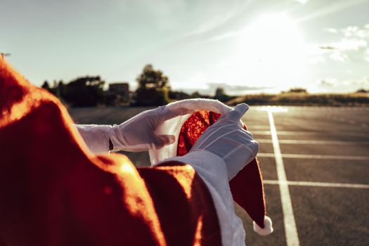 unrecognizable santa claus putting his santa hat on