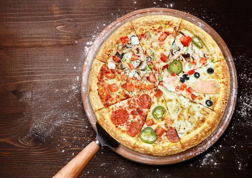 mix of eight different pizzas on a wooden background. menu concept of choice and diversity