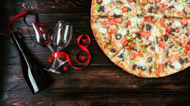 dinner for two in honor of Valentine's Day with pizza and wine.