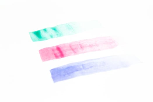 Collection of green, pink and purple smears of acrylic paint isolated on white background.