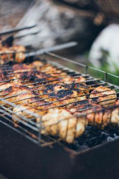 Grilled chicken thighs on the flaming grill.