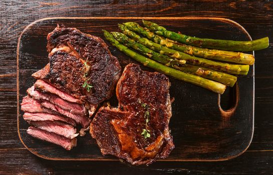 tasty and juicy steak and asparagus half fried in a frying pan and sprinkled with grated Parmesan cheese