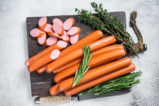 German raw Frankfurter sausages on a wooden board. White background. Top view.