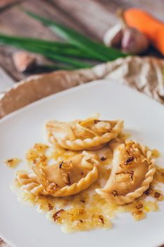 Dumplings, filled with meat and served with fried onion and meat pieces. Varenyky, vareniki, pierogi, pyrohy. Dumplings with filling