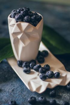 Fresh Blueberries in a bowl on dark background, top view. Juicy wild forest berries, bilberries. Healthy eating or nutrition.