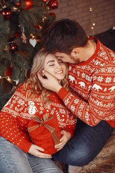 People in a Christman decorations. Man and woman in a red sweater. Family at home.