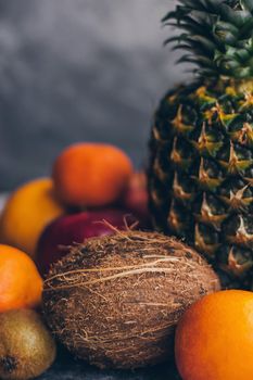 Colorful fresh tropical fruits on grey concrete background.