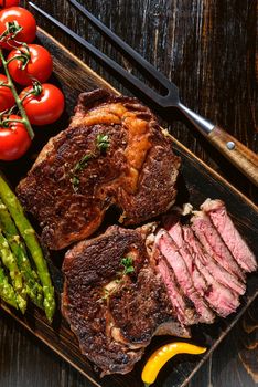 Dinner for two juicy delicious steaks, asparagus with parmesan and vegetables.