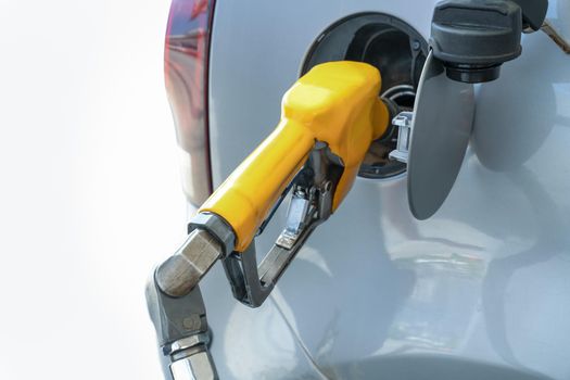 Refueling gun in tank of car, while refueling car with gasoline fuel, at gas station concept of service and fuel. Close-up.