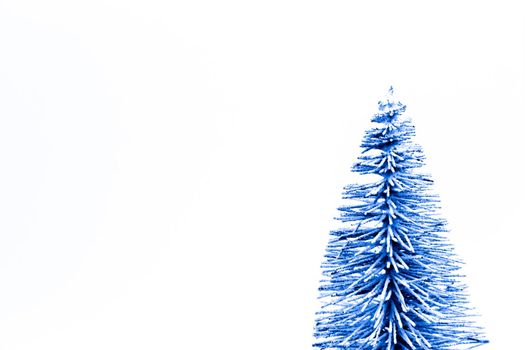 Trendy classic blue Christmas tree on a white background with copy space for text.