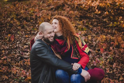 Happy couple in love embraces and has fun outside in the nature background. Woman is pregnant. Happy new parents