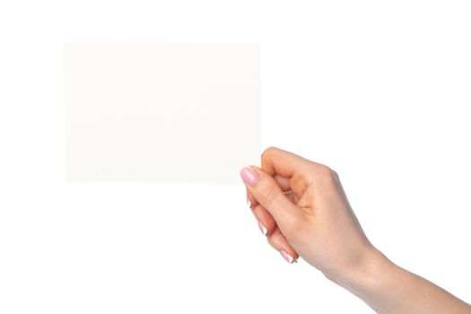 Woman's hand holding blank white sheet of paper isolated on white background