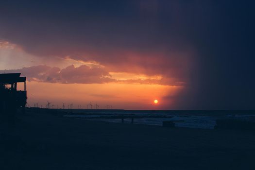 Sunrise sunset with beautifukls clouds and rays of light at the sea.