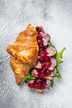 Duck breast Croissant sandwich with steak slices, arugula and sauce. White background. Top View.