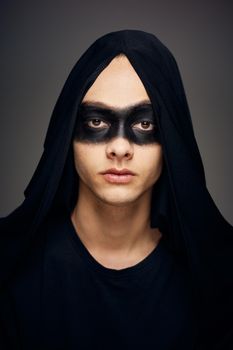 a man in a black mask Halloween costume ghost dark background. High quality photo