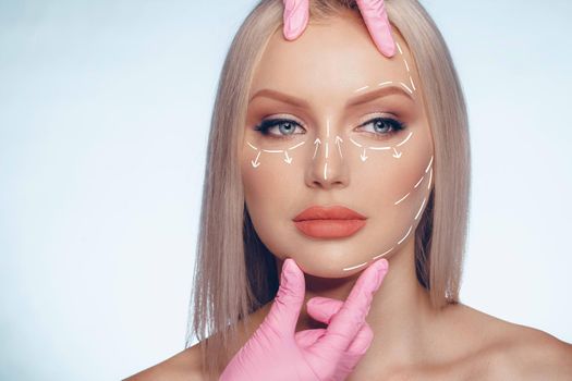 Portrait of attractive woman with arrows on her face skin for cosmetology