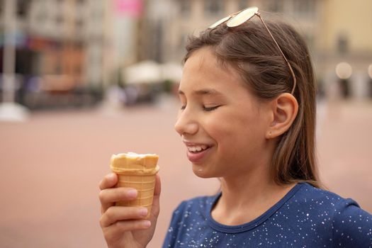 Portrait of a happy child with ice cream in hands on a city street